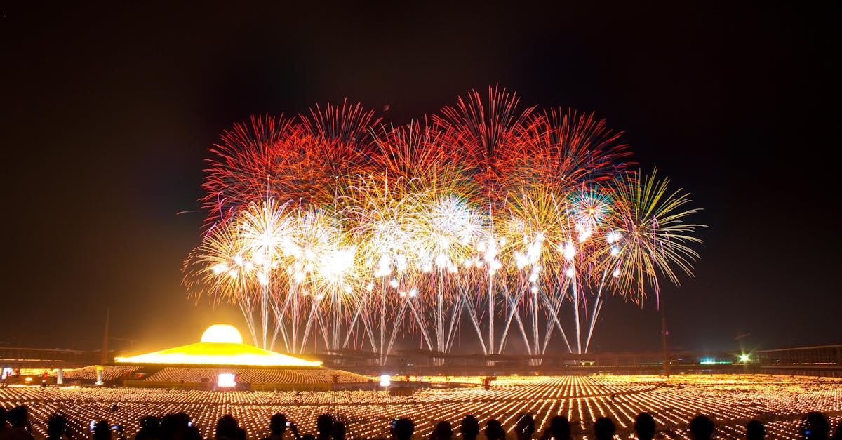 Vibrant fireworks illuminate the night sky above a Buddhist temple during a festival celebration.